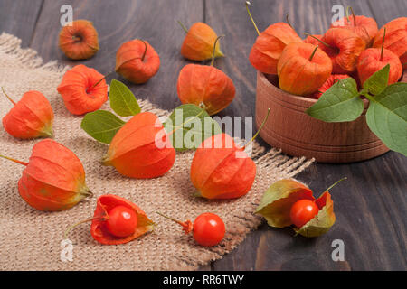 Physalis éparpillés sur une table en bois foncé Banque D'Images