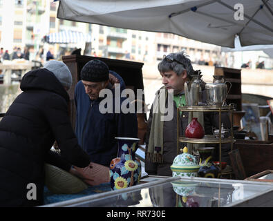 Milan, Italie. Feb 24, 2019. Personnes visitent le marché des antiquaires le long du Naviglio Grande à Milan, Italie, 24 février 2019. Le marché des antiquaires, organisé par l'Association de Naviglio Grande, a lieu le long des rives du canal Naviglio Grande, une à Milan, le dernier dimanche de chaque mois. Plus de 380 exposants ont apporté leurs mobilier vintage, des bijoux, des livres, des gravures et des accessoires pour le marché de février. Le marché a attiré les amateurs d'antiquités et les touristes de partout dans le monde. Credit : Cheng Tingting/Xinhua/Alamy Live News Banque D'Images