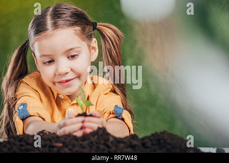 Focus sélectif de la plantation de l'enfant jeune plant sur fond flou, concept de la journée de la terre Banque D'Images