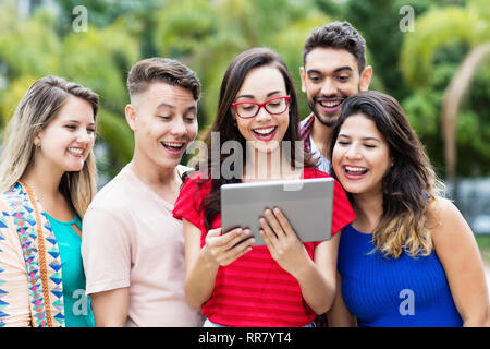 Français nerdy female student with tablet computer et le groupe d'étudiants internationaux à l'extérieur en été dans la ville Banque D'Images