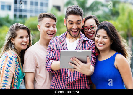 Heureux l'espagnol avec des élèves de l'ordinateur tablette hipster et groupe d'encourager les étudiants étrangers à l'extérieur en été dans la ville Banque D'Images