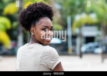 Belle femme avec des cheveux afro caraïbes piscine en été Banque D'Images