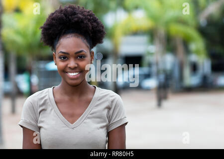 Rire Caraïbes femme avec cheveux afro en plein air l'été Banque D'Images