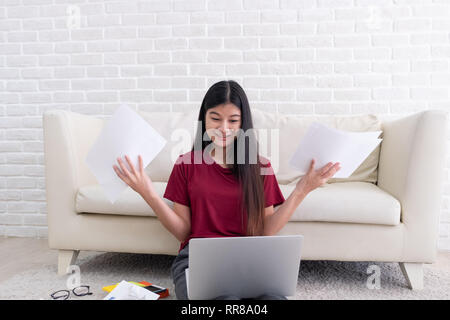 Asian woman freelancer souligner l'émotion tout en travaillant avec un ordinateur portable et des formalités administratives de canapé dans la salle de séjour en chambre.travailler à home concept Banque D'Images