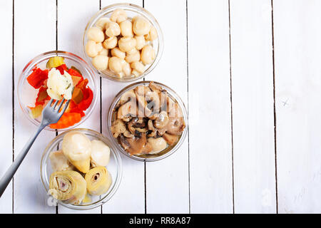 Vue de dessus de champignons fermentés, les artichauts et divers légumes sur fond de bois blanc. Selective focus Banque D'Images