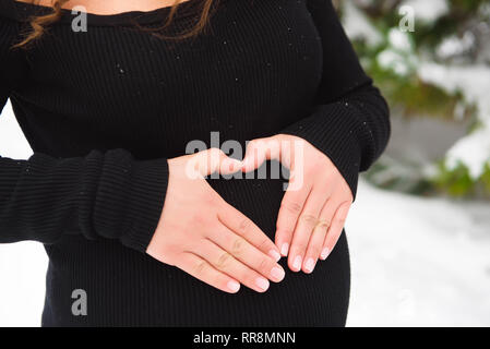 Détail de méconnaissable pregnant woman's belly en hiver. Banque D'Images