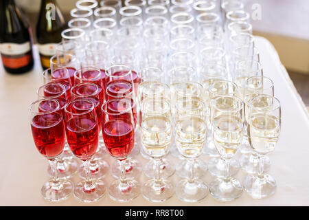 Une rangée de verres remplis de champagne sont alignés prêts à être servis. Banque D'Images