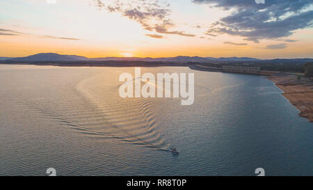 Vue aérienne de deux bateaux naviguant sur le lac en direction opposée au coucher du soleil en Australie Banque D'Images