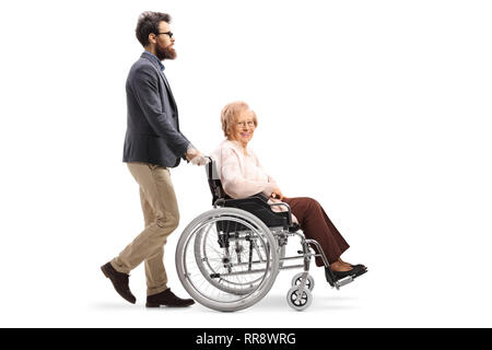 Profil de pleine longueur tourné d'un homme barbu poussant a senior woman en fauteuil roulant isolé sur fond blanc Banque D'Images