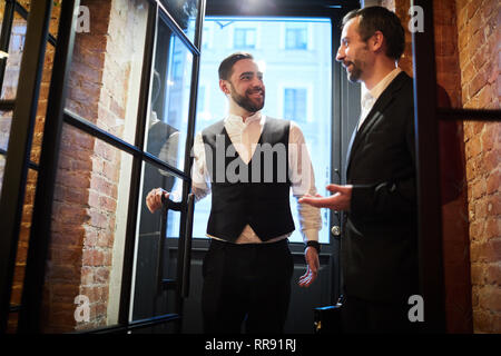 Deux hommes d'affaires entrant dans Restaurant Banque D'Images