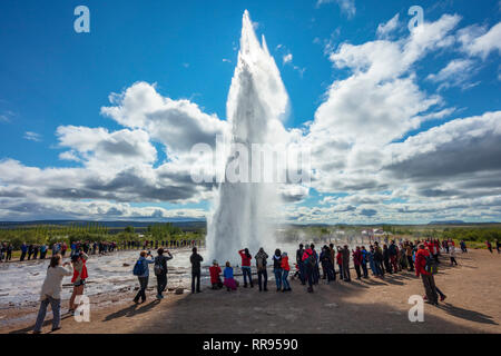 Les touristes regardant Strokkur geyser comme il éclate. Geysir, Sudhurland, Islande. Banque D'Images