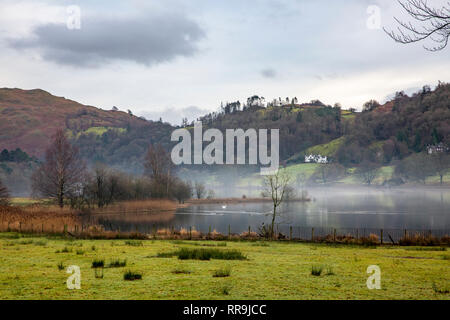 Tôt le matin, la brume au-dessus du lac de Grasmere Grasmere, dans le parc national de Lake District, Cumbria, Angleterre Banque D'Images