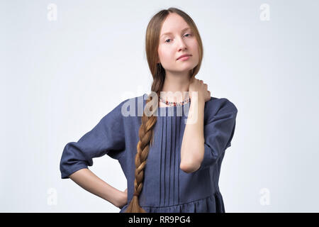 Jeune fille russe par tresse les cheveux, souriant avec confiance et friendly rechercher Banque D'Images
