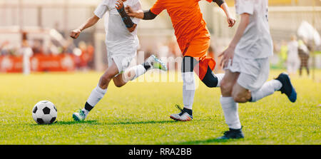 Soccer Shot. Les jeunes garçons Tournoi de soccer Match de football des coups sur le terrain d'herbe. Les joueurs de football Duel. L'exécution de jeunes joueurs de soccer s'école Banque D'Images