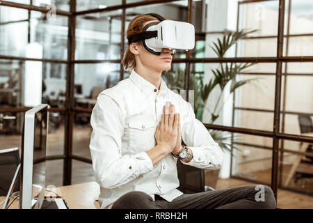 Nice bel homme méditant dans la réalité virtuelle Banque D'Images