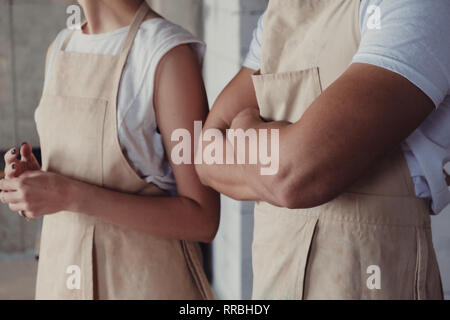 Les étudiants de poterie portant des tabliers et des leçons de leur maître céramiste au studio Banque D'Images