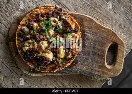 Pizza végétarienne délicieux avec du fromage et des verts sur la planche de bois sur la table. Vue d'en haut photo gros plan. L'horizontale. Banque D'Images