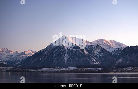 Le lac de Thoune et le Niesen mountain pendant le crépuscule d'une réflexion de petit village des lumières dans le lac. Banque D'Images