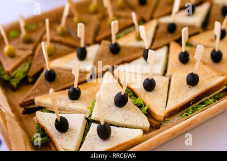 Photo en gros plan d'un club sandwich. Sandwich avec jambon, jambon, salade, légumes, salade, et les olives sur un pain de seigle en tranches sur un background Banque D'Images