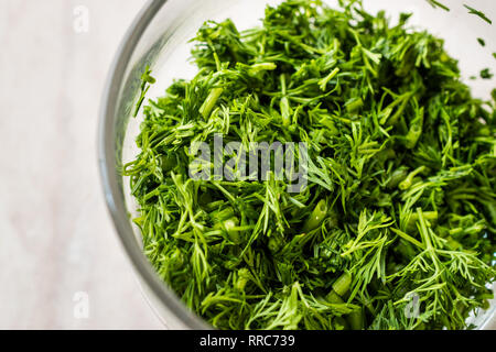 L'aneth haché dans un bol en verre pour la salade. L'alimentation biologique. Banque D'Images