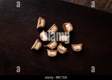 Pièces en chocolat remplis de tahini sur la surface en bois foncé / Tahin. Des collations bio. Banque D'Images