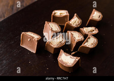 Pièces en chocolat remplis de tahini sur la surface en bois foncé / Tahin. Des collations bio. Banque D'Images