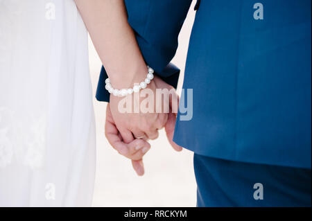 Les nouveaux mariés se serrent les coudes et tenant dans les bras Banque D'Images