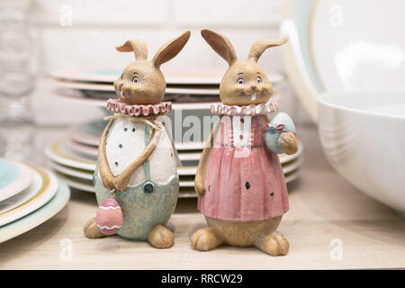 Deux poteries de Pâques partager sur un plateau de table de cuisine. Figurines en céramique pour servir la table de fête. Selective focus Banque D'Images