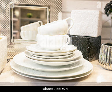 Une pile de vaisselle de porcelaine blanche vide propre sur une étagère. Ustensiles de cuisine dans l'intérieur du magasin ou à la maison. Banque D'Images