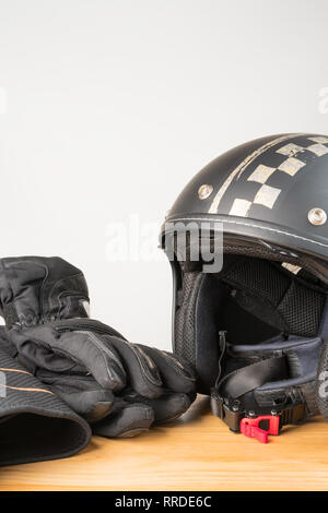 L'équipement de protection moto - face ouverte casque, gants et une ceinture sur un fond de bois. Orientation verticale. L'espace de copie sur le dessus. Banque D'Images