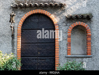 Arche en brique rouge avec porte en bois avec clous et photographie Banque D'Images