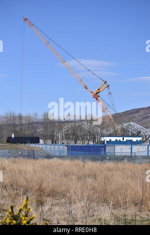 Grue unique travaillant sur Scottish Sea Farms' du bâtiment en construction à Barcaldine, Argyll. Portrait majestueux contre le ciel bleu. Banque D'Images