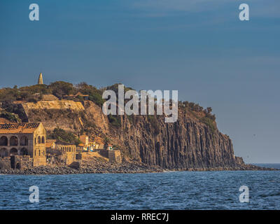 Vue sur l'île de Gorée avec un monument mémorial visible sur la partie supérieure et de hautes roches provenant de l'océan. L'île de Gorée. Dakar, Sénégal. L'Afrique. Banque D'Images