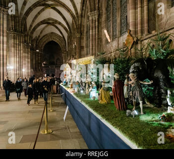 STRASBOURG, FRANCE - DEC 23, 2017 : scène Nativité crèche dans la chapelle Notre-Dame de la cathédrale de Strasbourg pendant les vacances d'hiver, représentant la naissance de Jésus - et présentant plusieurs personnages et les gens d'admirer les statues Banque D'Images