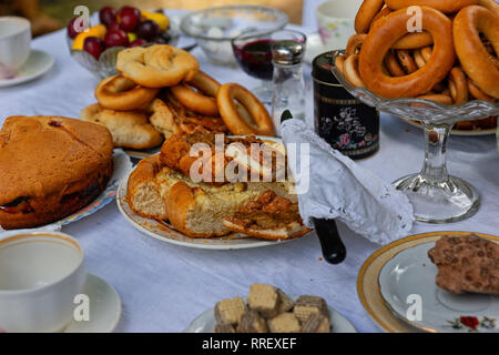 Détails d'une table de thé. Service à thé, des ustensiles, des plats, et des vases remplis de délicieux gâteaux, tartes, confiture etc. tea party d'été Banque D'Images