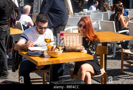 Couple avec des boissons regardant les menus dans un café en plein air de outdoor​ à Séville, Espagne Banque D'Images