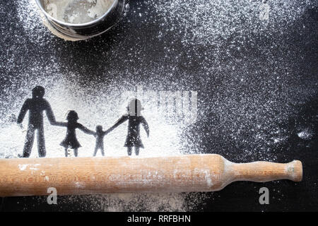 La figure de la farine en la forme de chiffres de la famille sur un tableau noir. La cuisson des pizzas. Le concept de divertissement familial. Banque D'Images