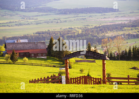 Vert printemps paysage rural. Maison et village sur les collines. Clôture avec arch et Gate. Région de Malopolska en Pologne Banque D'Images