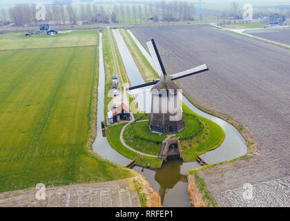 Moulin à vent hollandais typique du 17e siècle tourné du dessus avec un bourdon entouré par un canal dans les domaines de l'Holland Banque D'Images