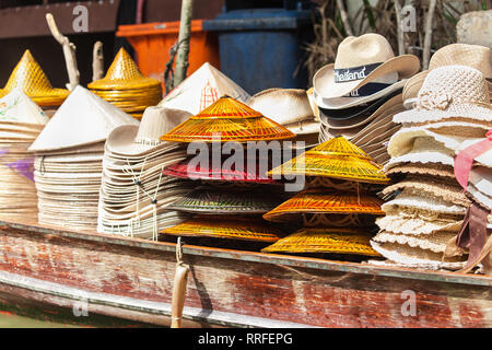 Des tas de chapeaux sur un bateau en bois au marché flottant de Damnoen Saduak, Ratchaburi, Thaïlande. Banque D'Images