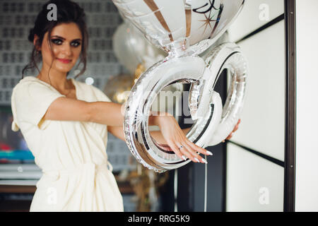 Brunette mariée montrant la main avec anneau de mariage et de se cacher la face. Banque D'Images