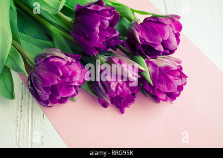 Fleurs tulipe Ultraviolet sur shabby chic blanc table en bois avec place pour le texte. Bouquet de tulipes au printemps violet. Heureuse Fête des Mères. N internationale Banque D'Images