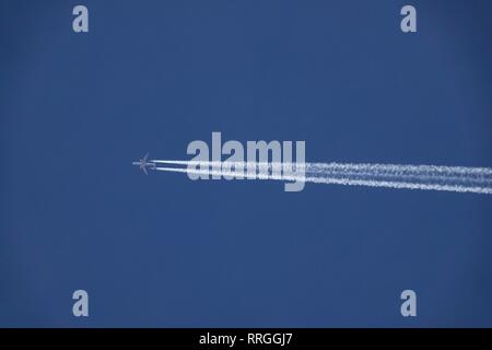 Comme un avion vole dans le ciel elle laisse une traînée de chemin dans son passé. Banque D'Images