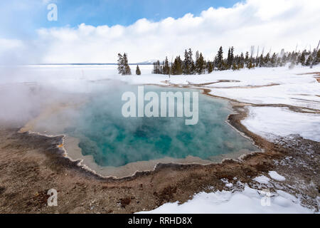 La vapeur s'élève de la piscine noire printemps chaud en hiver à la West Thumb Geyser Basin, 19 février 2019 dans le Parc National de Yellowstone, Wyoming. Banque D'Images