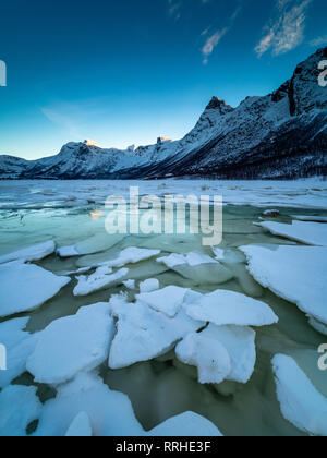 Freinage de la glace sur un lac gelé avec des montagnes en arrière-plan sur la péninsule de Kjerringøy dans le nord de la Norvège. Banque D'Images