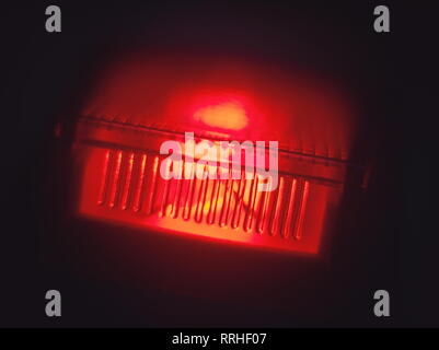 Interrupteur d'alimentation rouge lumineux dans l'Obscurité Macro closeup Banque D'Images