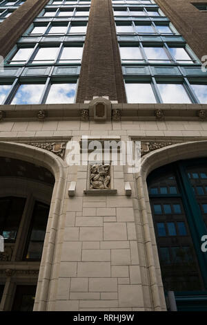 Gros plan d'une figurine sur le mur extérieur d'une ancienne façade d'édifice architectural, rue Saint-Antoine, Vieux-Montréal, Québec, Canada. Banque D'Images