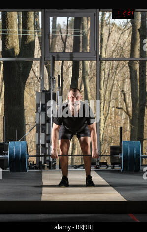 Deadlift tentative. Jeune homme essayant de soulever de lourdes barbell Banque D'Images