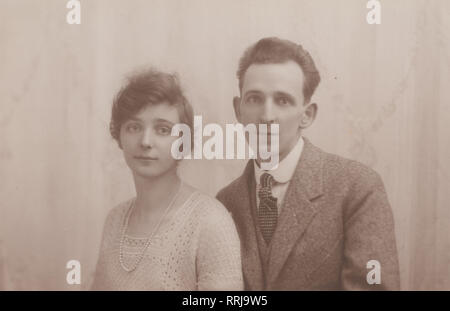 Londres Carte postale photographique montrant un homme et une femme à Noël en 1925. Banque D'Images