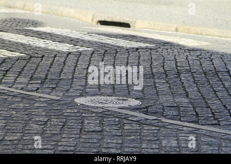 Couvercle de trou d'homme sur une rue pavée, Evora, Alentejo, Portugal Banque D'Images